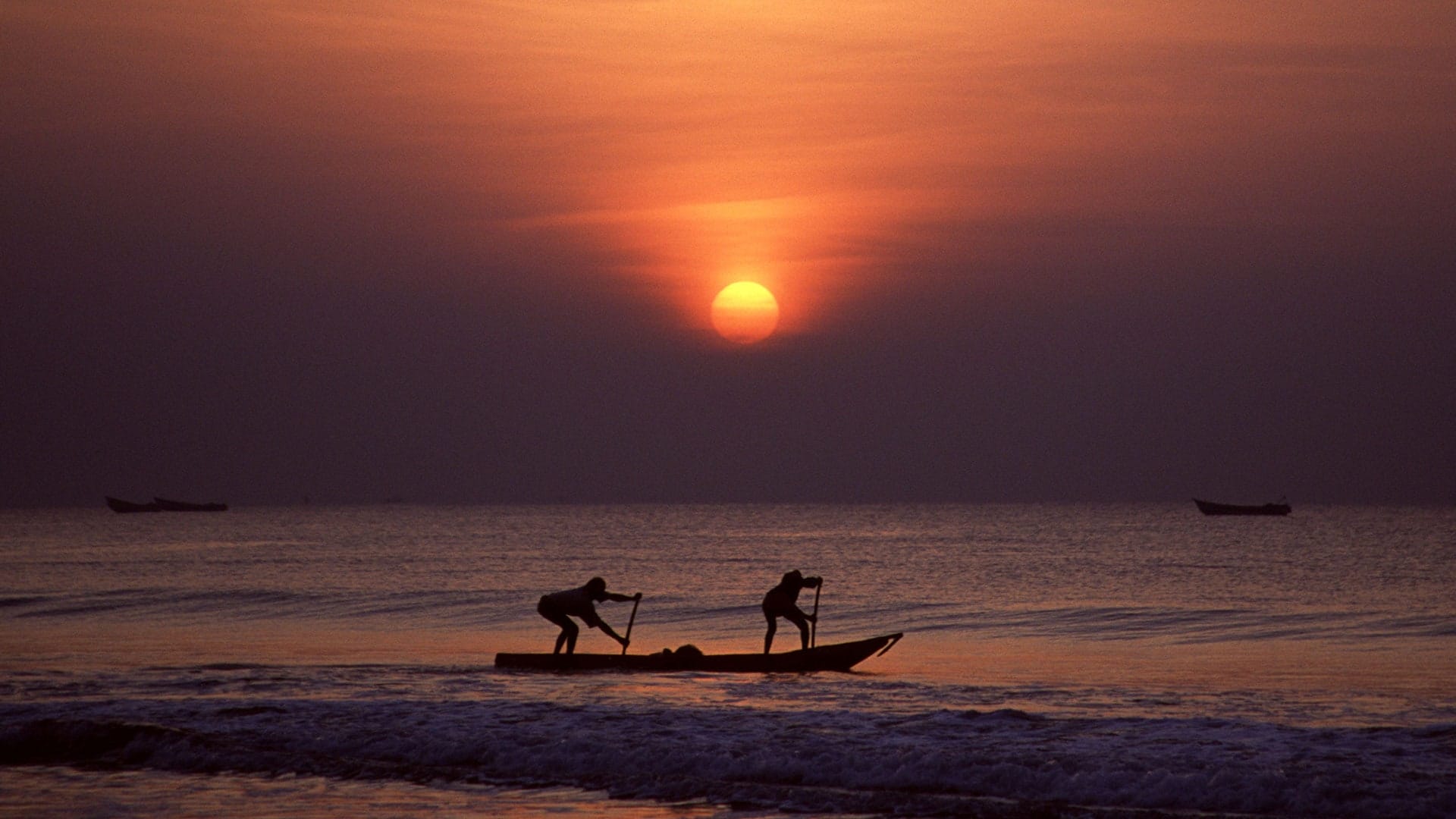 Sea beach with sun rise and fishing boat with people